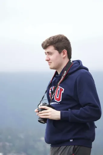 Headshot of Nathan Jacobson holding a camera